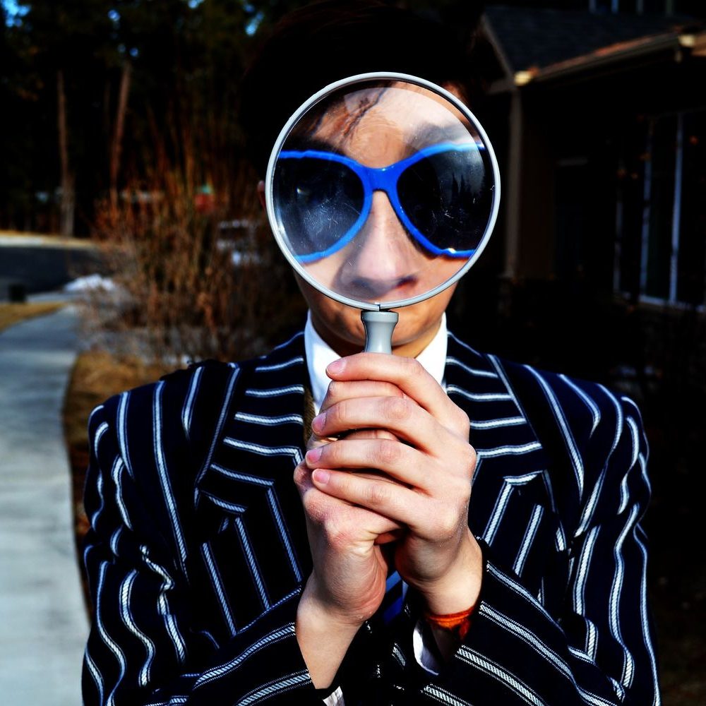 homme avec une loupe et des lunettes bleues homme avec une loupe et des lunettes bleues